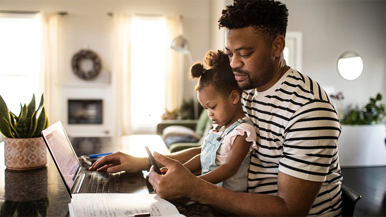 person with child using phone and laptop