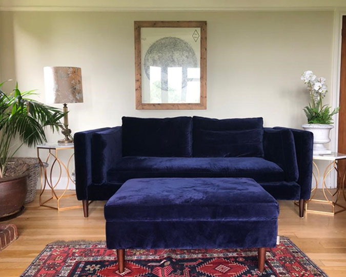 A velvet navy two-seater sofa.