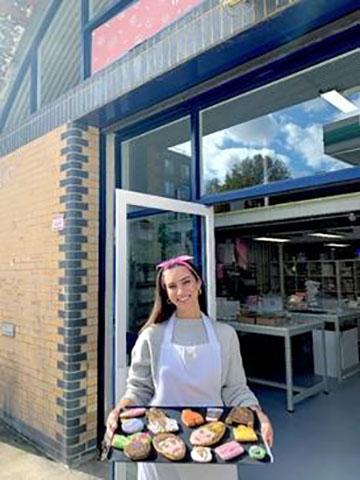 Stephanie Giordano, owner of 'Baked by Steph', holding a tray of biscuits.