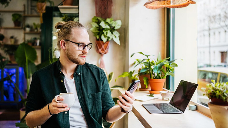 Business owner with mobile and coffee