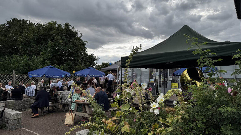 people eating food at tables outside