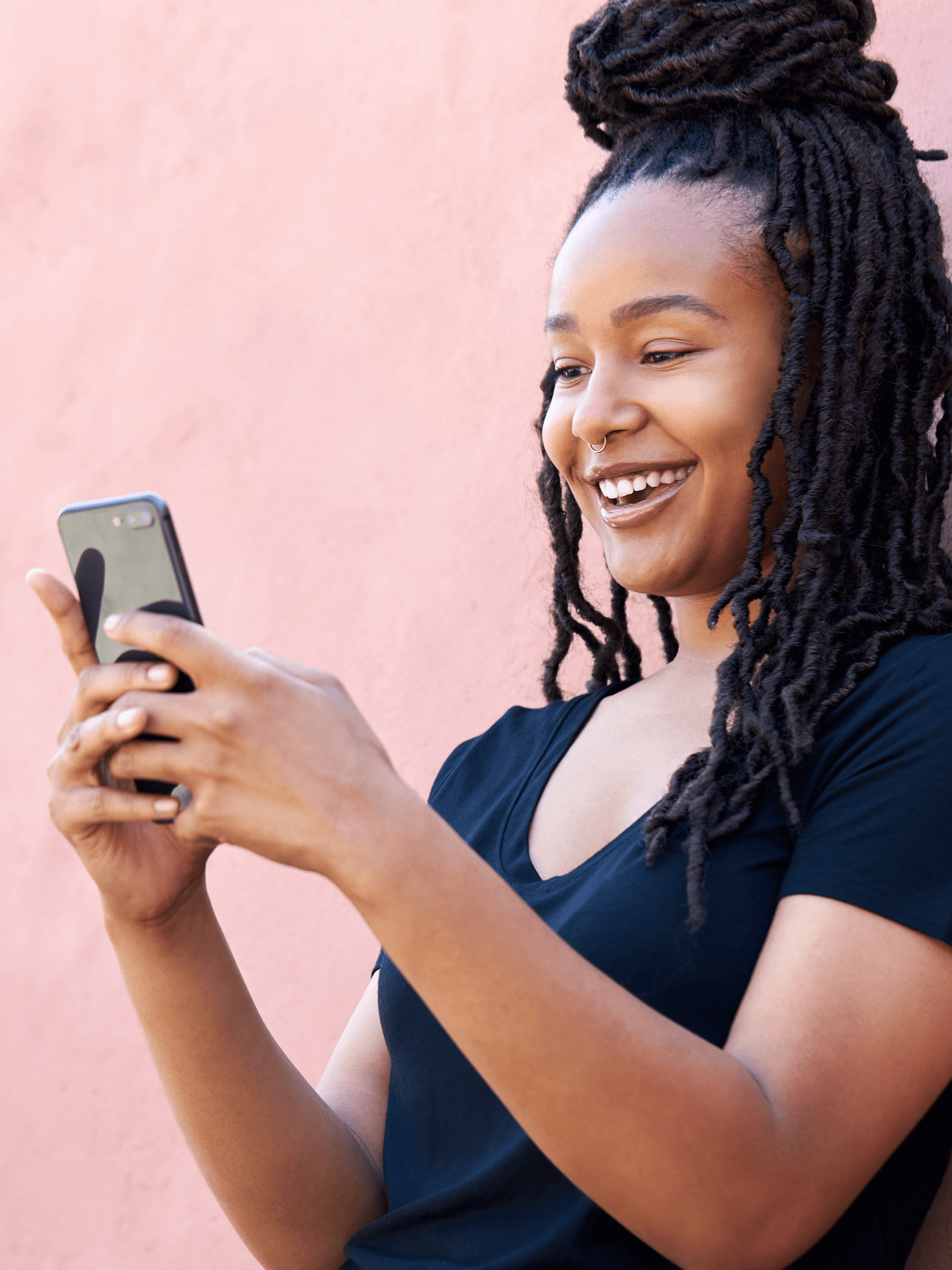 A woman smiling while using a smart phone