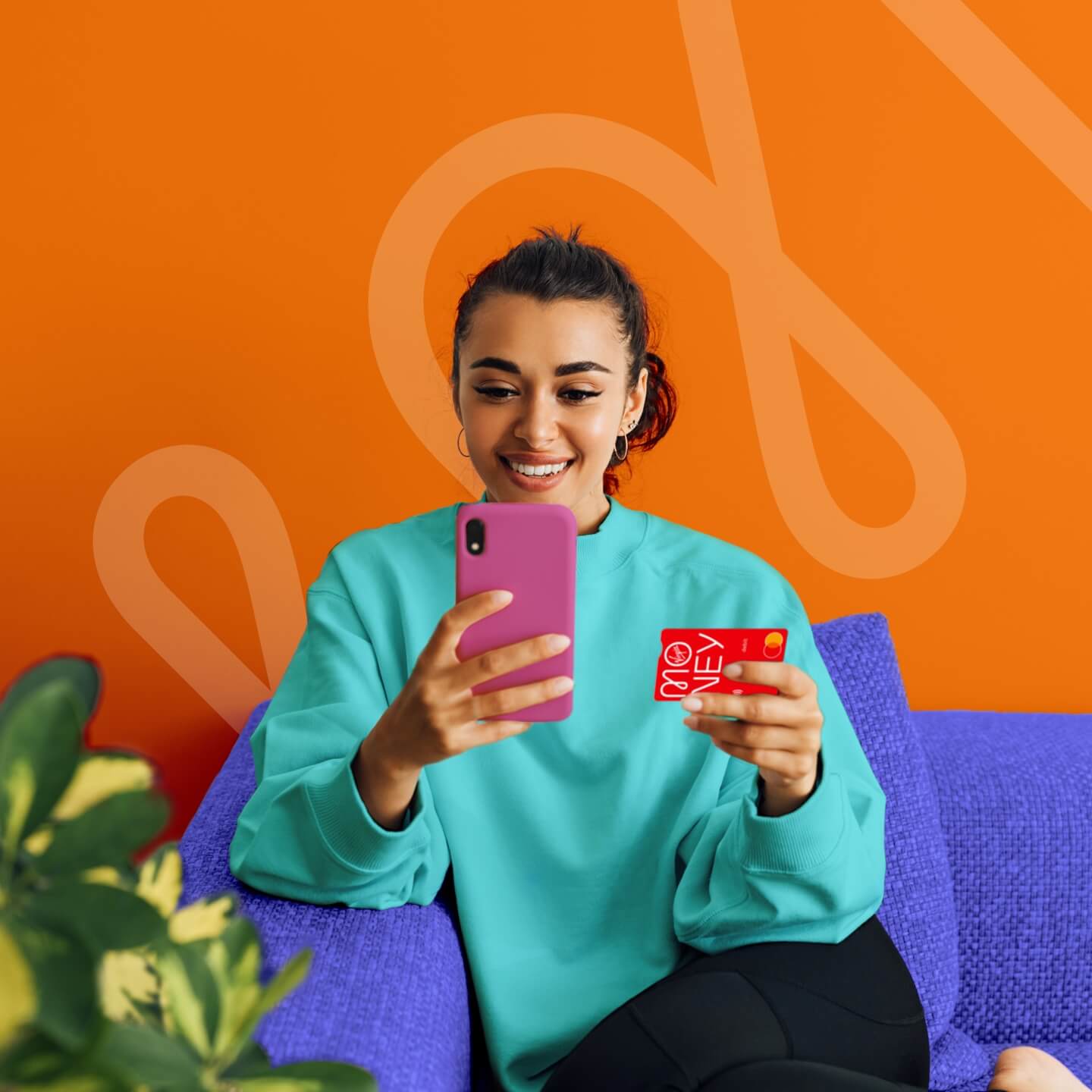 smiling woman holding a pink phone and virgin credit card