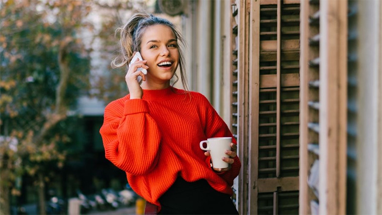 Person drinking coffee while speaking on the phone